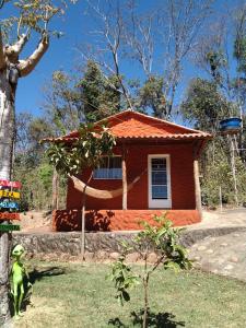 una pequeña casa con techo naranja en Sítio Aroeira Chalés, en São Jorge