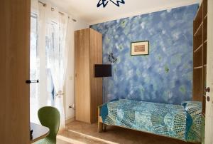 una camera da letto con una parete blu e un letto. di SUNSET HOUSE a San Leone