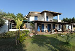 una grande casa bianca con portico e cortile di SUNSET HOUSE a San Leone