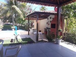 a patio with a pergola and a table and chairs at Casa na Praia dos Carneiros - Tamandaré in Tamandaré
