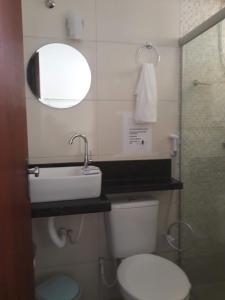 a bathroom with a toilet and a sink and a mirror at Casa na Praia dos Carneiros - Tamandaré in Tamandaré