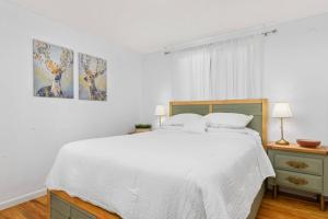 biała sypialnia z dużym łóżkiem i oknem w obiekcie The House at Gery National w mieście Lake Oswego