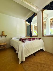 ein Schlafzimmer mit einem Bett in einem Zimmer mit einem Fenster in der Unterkunft Casa AHAU in San Marcos La Laguna