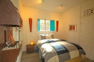1 dormitorio con 1 cama y chimenea en Dantica Cloud Forest Lodge, en San Gerardo de Dota