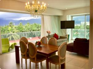 a living room with a table and chairs and a couch at Departamentos Oceanfront Icon Vallarta in Puerto Vallarta