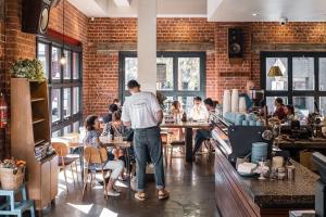 a man standing in a restaurant with people sitting at tables at Best Central House - SLEEPS 12 !! in Wagga Wagga