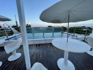 a table and chairs and an umbrella on a deck at Israel Flat Tambaú in João Pessoa