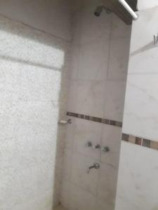 ein weißes Bad mit einer Dusche und einem Waschbecken in der Unterkunft León Apart -un dormitorio- in Corrientes
