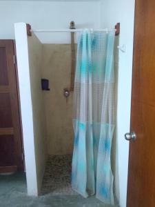 La salle de bains est pourvue d'une douche avec rideau. dans l'établissement Hostal Jardin, à Mahahual