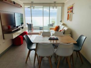 ein Wohnzimmer mit einem Tisch, Stühlen und einem TV in der Unterkunft Departamento Club Oceano in Coquimbo