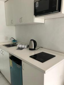 a kitchen with a counter top with a microwave at Acapulco Hotel y suites mediterrane in Acapulco