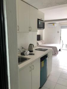 a kitchen with a sink and a room with a bed at Acapulco Hotel y suites mediterrane in Acapulco