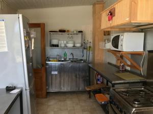 a small kitchen with a refrigerator and a microwave at Ancud Petit Hostal in Ancud