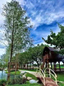 a park with a tree and a building and a pond at Bali Lover in Ji'an