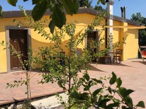 Apecchio的住宿－Timeless Holiday Home in Apecchio with Garden，黄色的房子前面设有桌椅