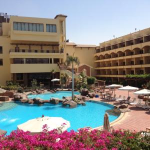un hotel con piscina frente a un edificio en Amarante Pyramids Hotel, en El Cairo
