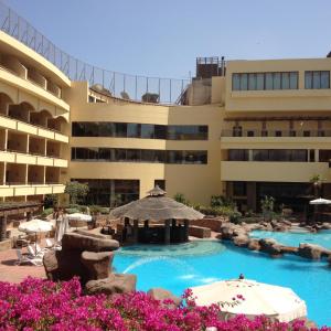 a hotel with a swimming pool in front of a building at Amarante Pyramids Hotel in Cairo