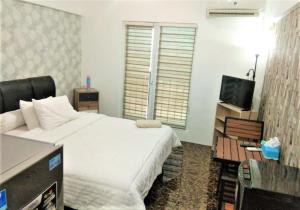 ein Schlafzimmer mit einem großen Bett und einem TV in der Unterkunft Apartemen Mutiara Bekasi by Veeroom in Bekasi