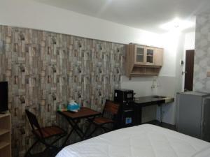 a room with a bed and a kitchen with a table and chairs at Apartemen Mutiara Bekasi by Veeroom in Bekasi