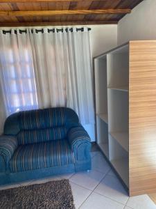 a blue couch in a living room with a window at Pousada Vale Verde in Monte Verde +54 photos