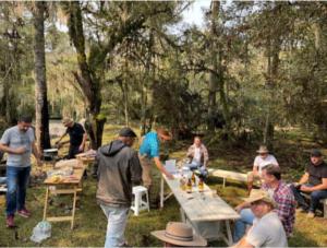 eine Gruppe von Menschen, die um einen Picknicktisch stehen in der Unterkunft CASA DE CAMPO FAZENDA DAS PELOTAS in Bom Jardim da Serra + 11 Fotos