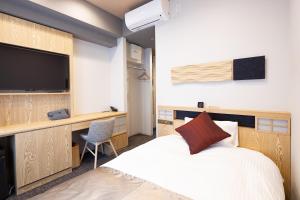 倉敷市にあるホテル グラン・ココエ倉敷のベッドとテレビが備わるホテルルームです。
