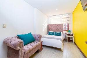 - une chambre avec un lit, un canapé et une chaise dans l'établissement Ayenda Dorado Boutique, à Bogotá