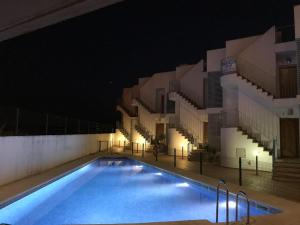 basen przed budynkiem w nocy w obiekcie Costa del Algarve w mieście Villablanca