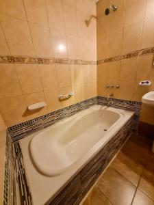 a bath tub in a bathroom with a sink at El Descanso Hotel in Termas de Río Hondo