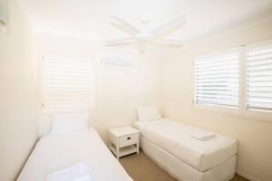 a bedroom with two beds and a ceiling fan at BEACHBREAK - 100m to beach - sleeps 6 in Point Lookout