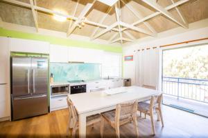 a kitchen with a white table and a refrigerator at BEACHBREAK - 100m to beach - sleeps 6 in Point Lookout