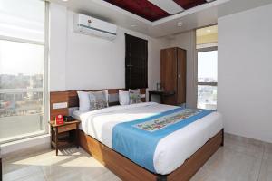 a bedroom with a large bed and a large window at Vinayak Inn Hotel in Jaipur