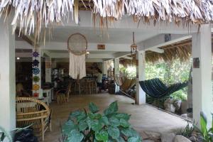 een kamer met stoelen en hangmatten in een restaurant bij Casa AHAU in San Marcos La Laguna