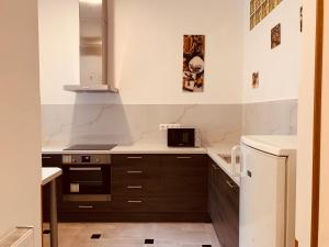 eine Küche mit braunen Schränken und einer Mikrowelle in der Unterkunft West Residence in Budapest