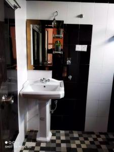 La salle de bains est pourvue d'un lavabo blanc et d'un miroir. dans l'établissement La Rose Home Stay, à Nuwara Eliya