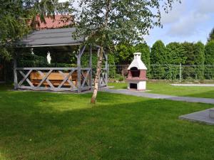 a wooden shelter with a bird house in a yard at Cicha 3 in Sztutowo