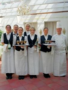 um grupo de pessoas segurando pratos de comida com um chef em Niebüller Hof em Niebüll