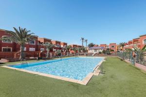 duży basen w środku podwórza w obiekcie Villa Tucanes w Corralejo