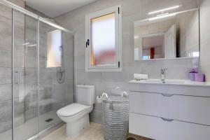 łazienka z toaletą, umywalką i prysznicem w obiekcie Villa Tucanes w Corralejo