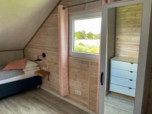 Kleines Zimmer mit einem Bett und einem Fenster in der Unterkunft Magic Home Łeba in Łeba