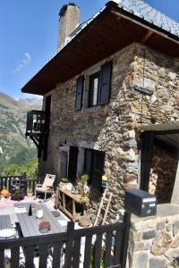 een stenen huis met een tafel en een grill bij Villa Le Ponteil in Les Deux Alpes