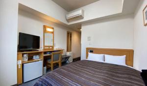 Postel nebo postele na pokoji v ubytování Hotel Route-Inn Tsubamesanjo Ekimae