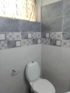 a white bathroom with a toilet and a window at Newly Renovated GuestHouse in Islamabad