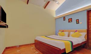 1 dormitorio con 1 cama con almohadas amarillas en Itsy By Treebo - Vailankanni Natures Inn en Panaji