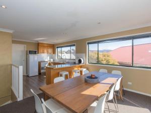 a kitchen and dining room with a table and chairs at Chalet De Neige 2 9 Jillamatong Street in Jindabyne