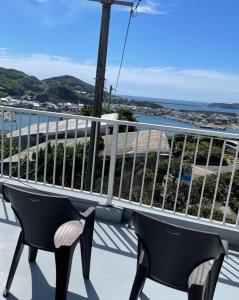 uma varanda com 2 cadeiras e vista para o oceano em Watatsumi no Yado 1981 - Vacation STAY 55945v em Iki