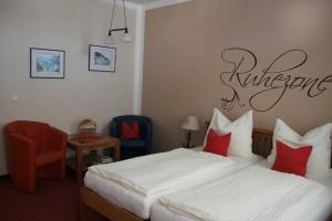 ein Hotelzimmer mit einem Bett mit roten Kissen in der Unterkunft Villa Fanny in Sassnitz
