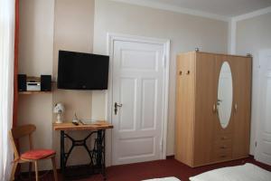 Dieses Zimmer verfügt über ein Schlafzimmer mit einem Schreibtisch und einem TV. in der Unterkunft Villa Fanny in Sassnitz