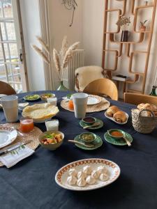 une table bleue avec des assiettes de nourriture dans l'établissement Chambres d'hôtes - La Maison 19, à Niort