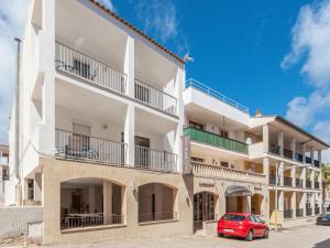 a red car parked in front of a building at Apartamentos Lago in Colonia Sant Jordi